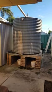 Old rainwater tank with signs of leaking on base